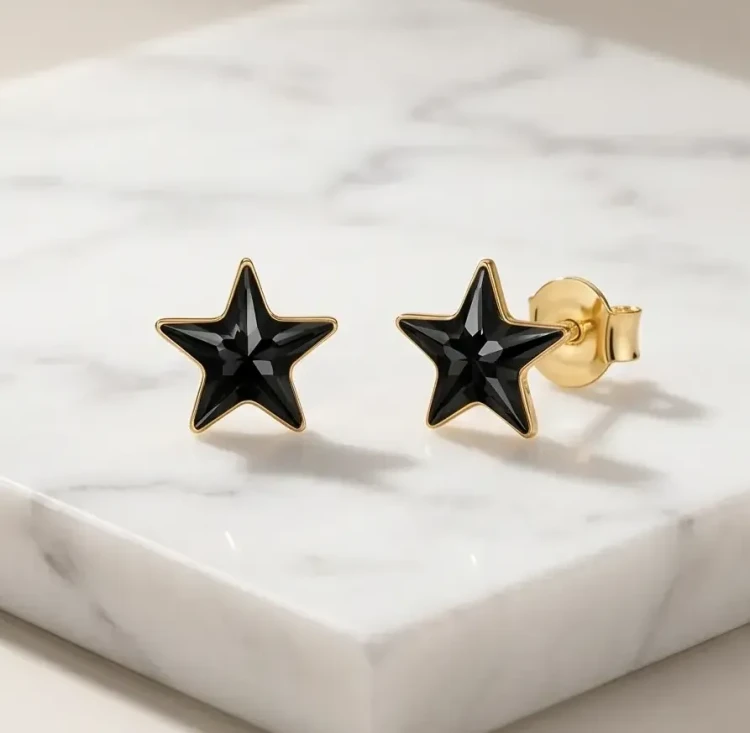 Eleganckie kolczyki damskie z czarną kryształową gwiazdką Swarovski® Jet i złoconym wykończeniem.